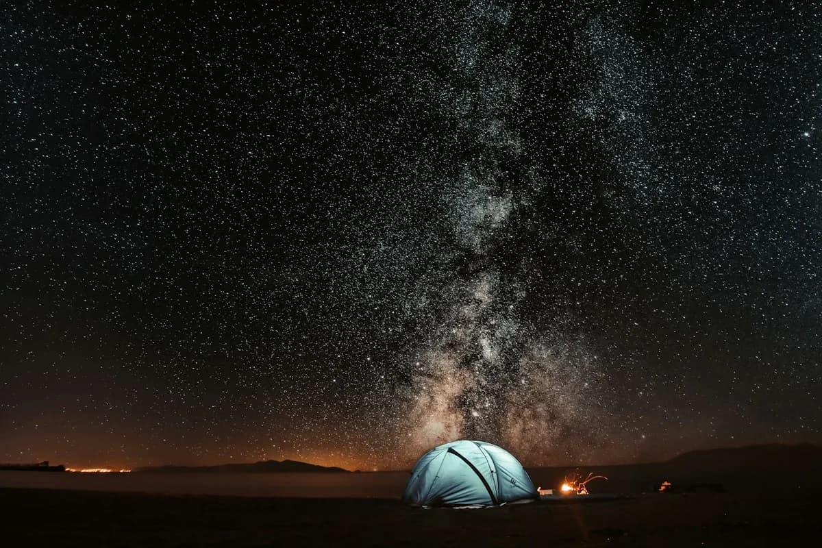 A tent beneath a star-filled night sky